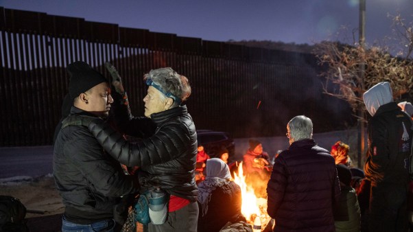 A minister in Arizona prays for a Colombian migrant waiting to be picked up by border patrol the night before Donald Trump's inauguration.