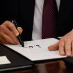 Trump signs executive order with a marker