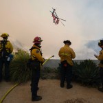An LA County helicopter does a water drop on the Palisade Fire in Los Angeles.