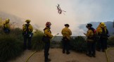 An LA County helicopter does a water drop on the Palisade Fire in Los Angeles.