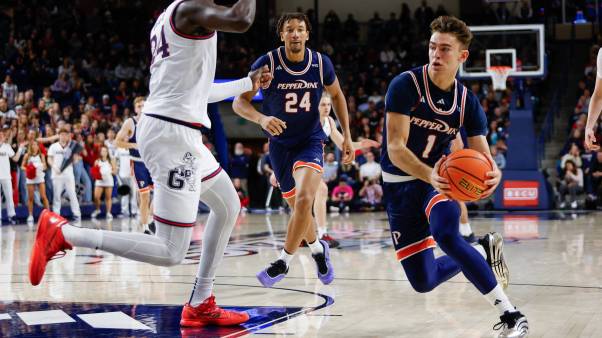 Basketball players wear Pepperdine's blue and orange uniforms during a game.