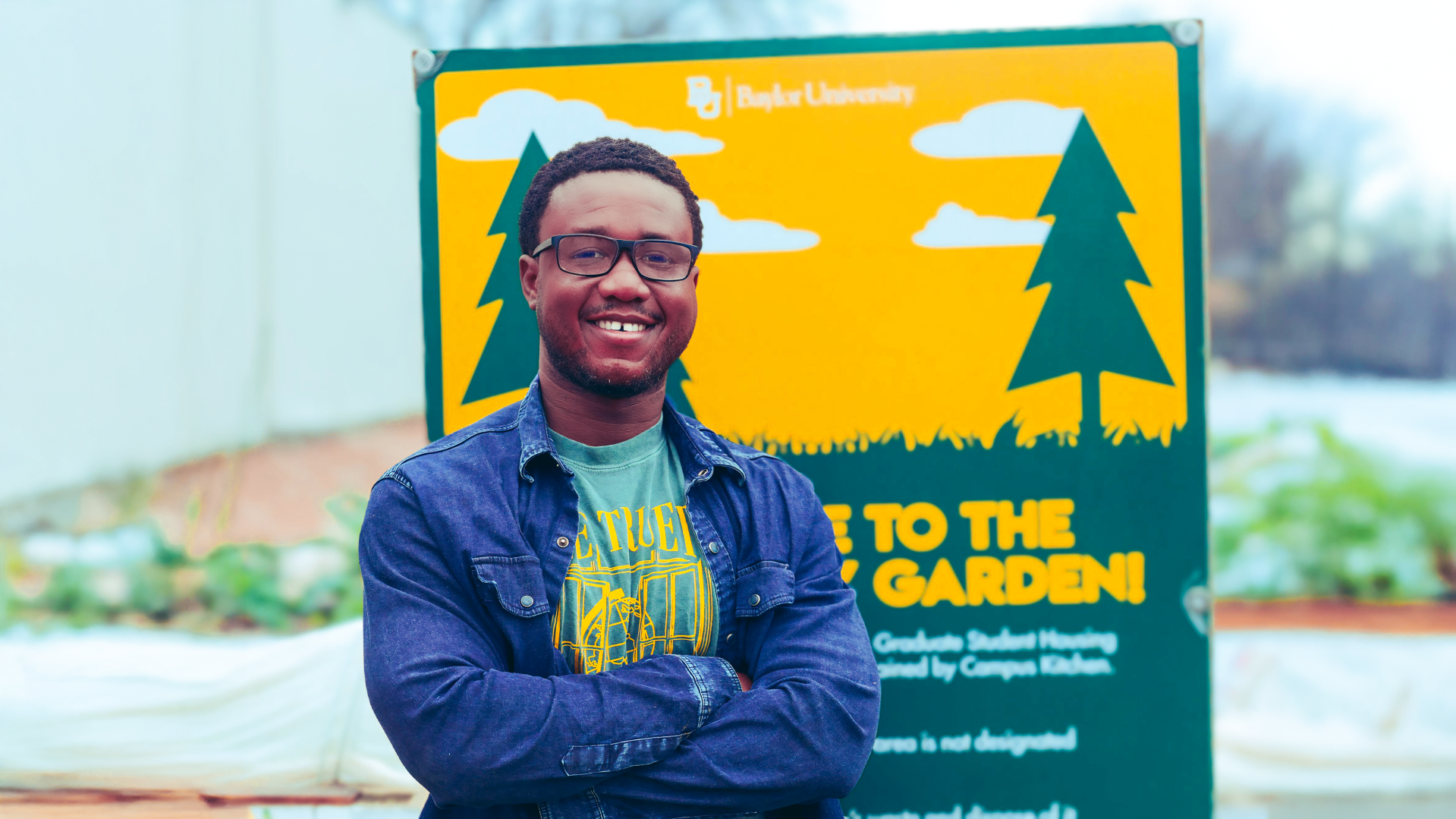 A picture of a seminary student standing in front of a community garden.