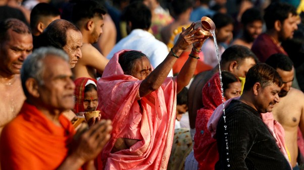 Pilgrims pray before taking a holy dip in Sangam during the Maha Kumbh Mela festival.