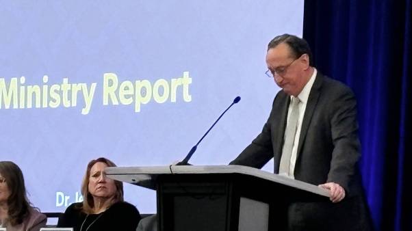 A man at a microphone with his head down