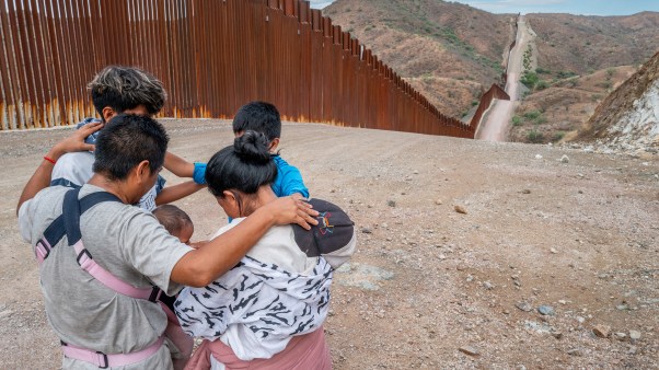 Migrant family praying at US border