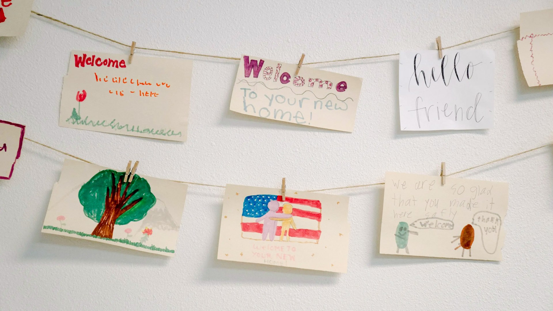 A string of welcome signs hand-drawn by kids