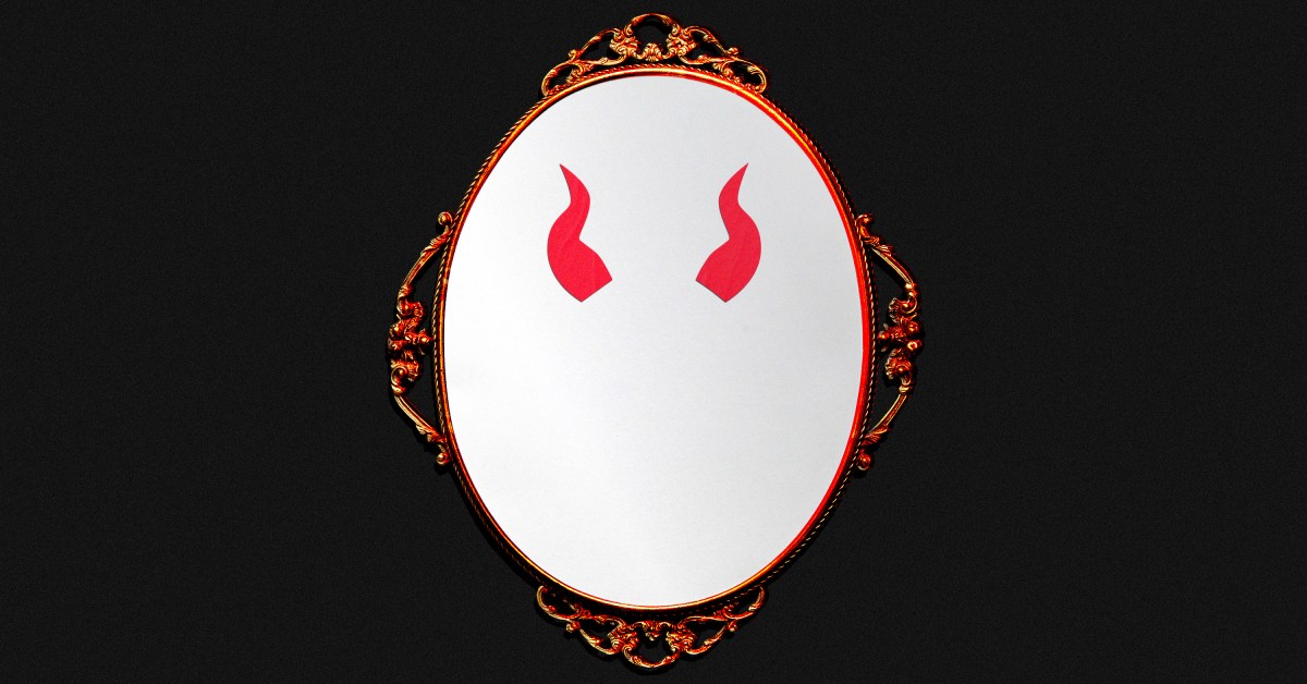 A mirror with devil horns on it.