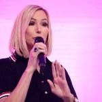 Paula White speaking in front of a pink screen