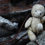 A stuffed animal bear in rubble