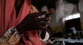 A mother holds the severely malnourished arm of her one-year-old in a hospital in Sudan.
