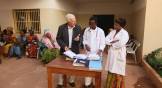 A white man consults with two African doctors at a clinic in Mali.