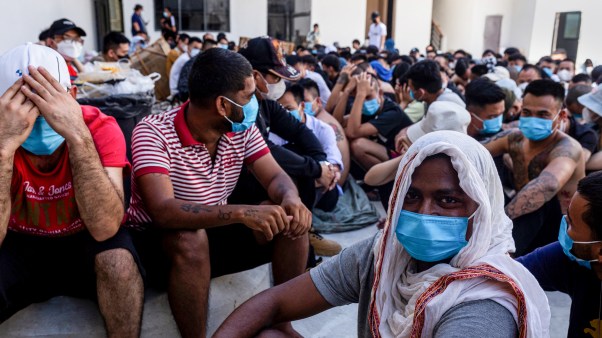 Scam center victims sit on the ground during a crackdown operation by the Karen Border Guard Force (BGF) in Myanmar.