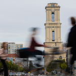 Blurry people walk past a church in Potsdam, Germany