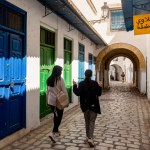 Two young Tunisian women walk in the traditionally decorated narrow streets of Tunis.