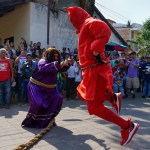 Salvadorans dressed as "Talcigüín" and Jesus dance during the tradition of Los Talcigüines in Texistepeque.