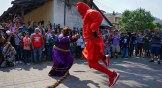 Salvadorans dressed as "Talcigüín" and Jesus dance during the tradition of Los Talcigüines in Texistepeque.