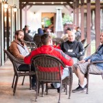 Group of men discussing around a table.