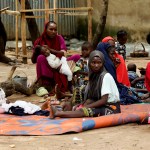 A group of civilians sits on the ground at Durumi Internally Displaced Persons camp in Nigeria.