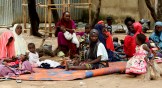 A group of civilians sits on the ground at Durumi Internally Displaced Persons camp in Nigeria.