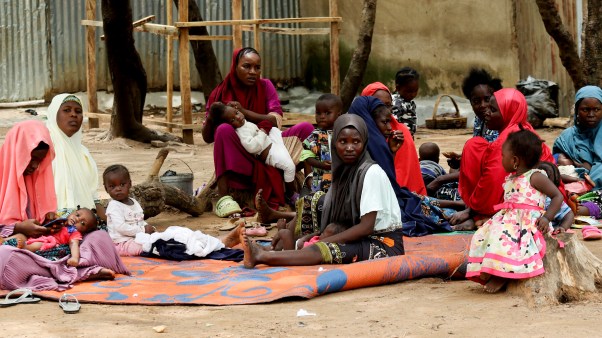 A group of civilians sits on the ground at Durumi Internally Displaced Persons camp in Nigeria.
