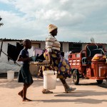 A poultry farmer in Zimbabwe prepares to go to market on her renewable energy electrical tricycle.