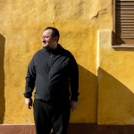 Dmitro Isaeiv standing in front of a yellow wall.