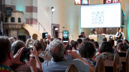 Visitors to St. Paul Church in Fürth, Germany, take part in a pre-recorded service created by ChatGPT in 2023.