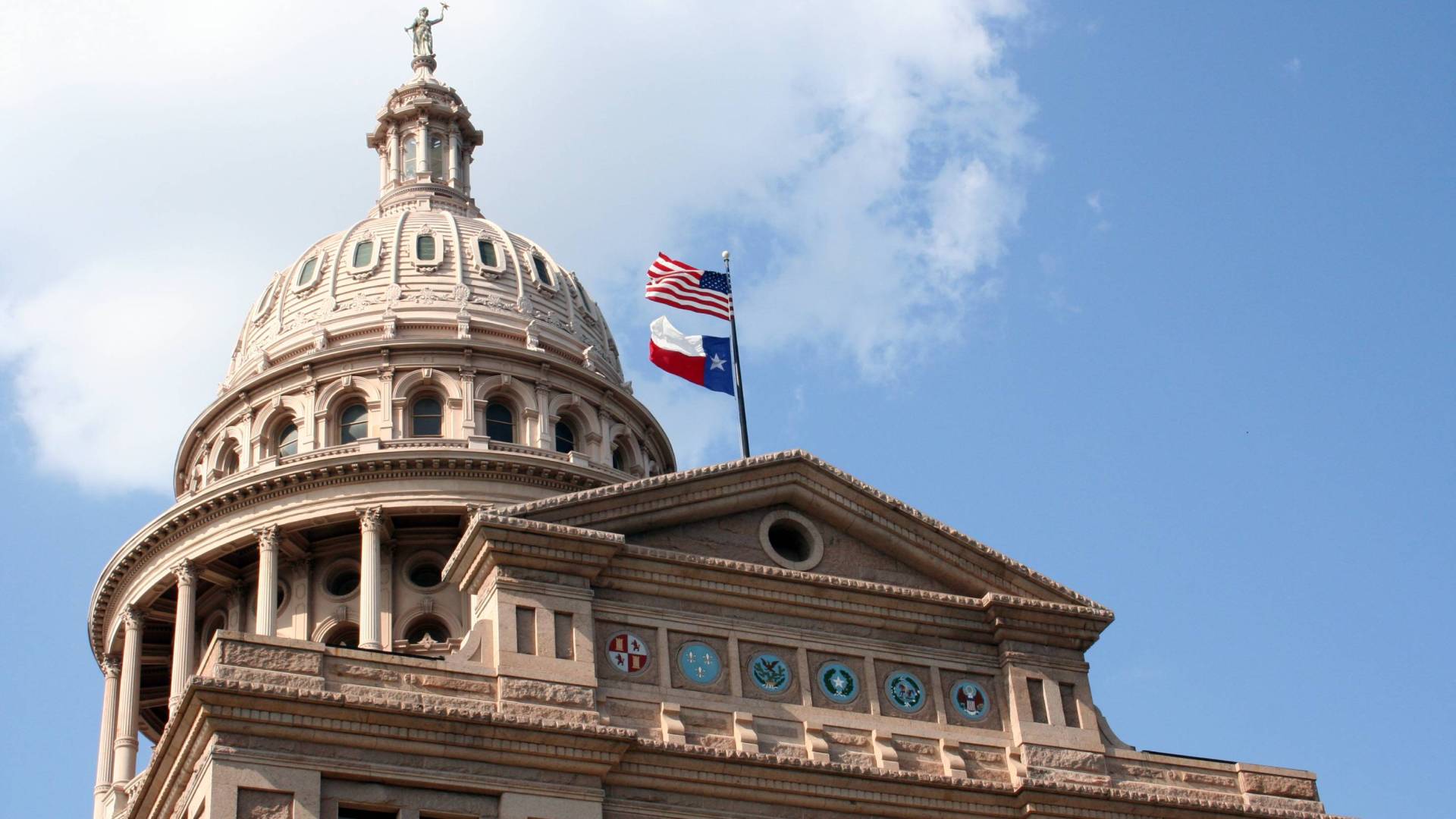 Texas Capitol in Austin with Texas flag and US flag