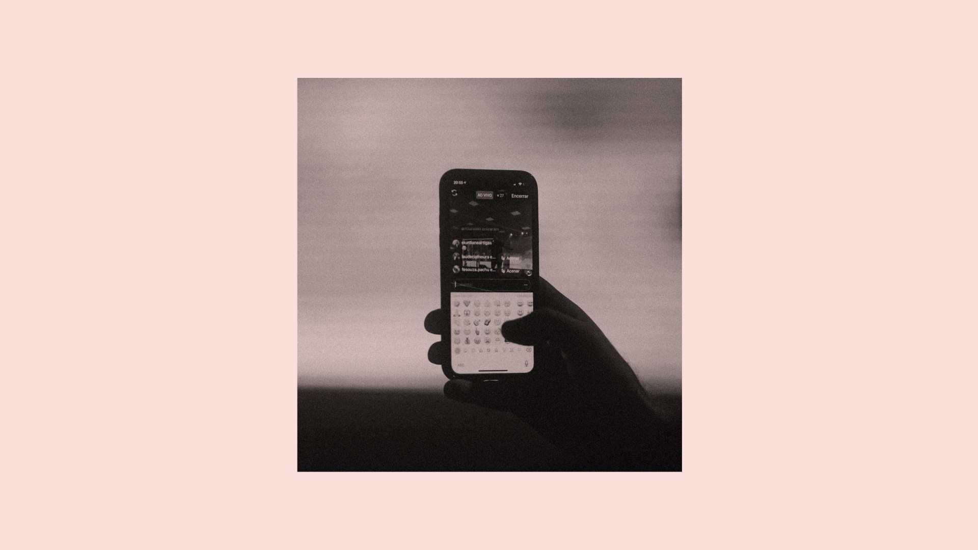 A person holding a phone with emojis