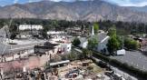 Aerial view of church ruins where people pray in circle with the mountains behind them