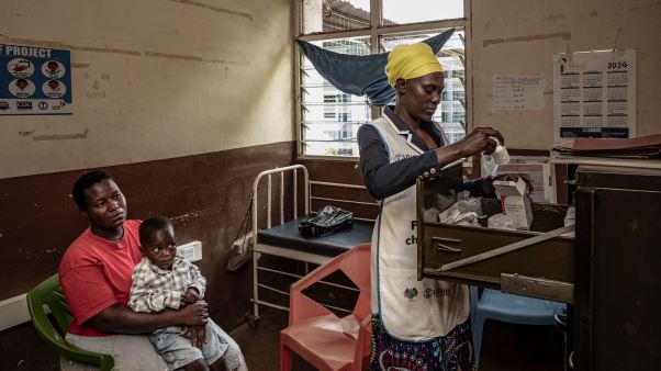 A mother and child await treatment in April at a Kenyan clinic that treats HIV/AIDS. Many such clinics are shuttering after USAID cuts.
