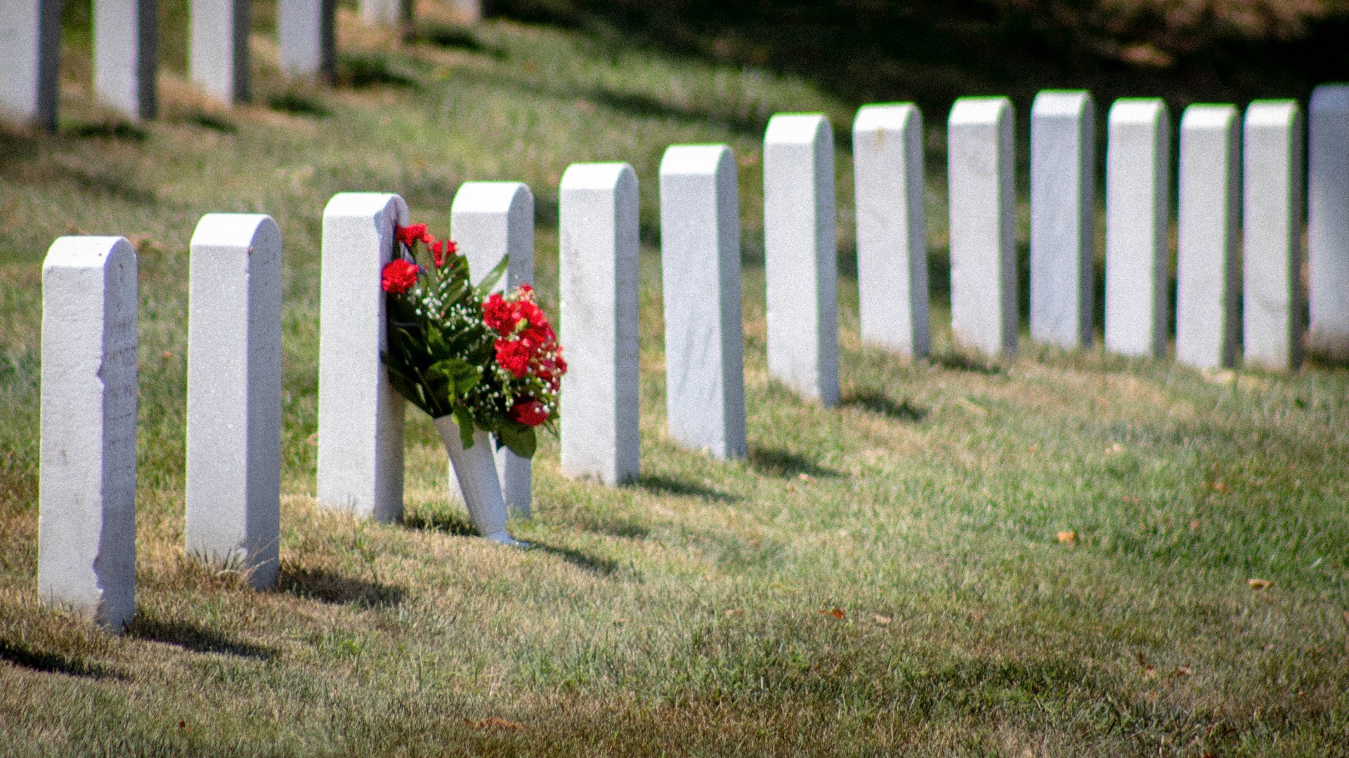 A military grave with flowers located at Arlington National Cemetery.