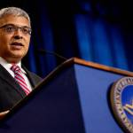 National Institutes of Health director Jay Bhattacharya speaks at a HHS podium with a blue curtain behind.
