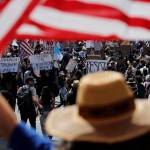 No Kings protester holds American flag