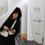 A woman comes out of a booth to cast her early vote in a polling station for the presidential election in South Korea.