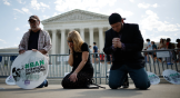 Protestors pray in front of the Supreme Court.