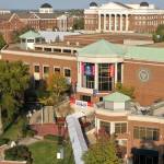 Brick campus buildings with columns, trees, grass, shown from overhead