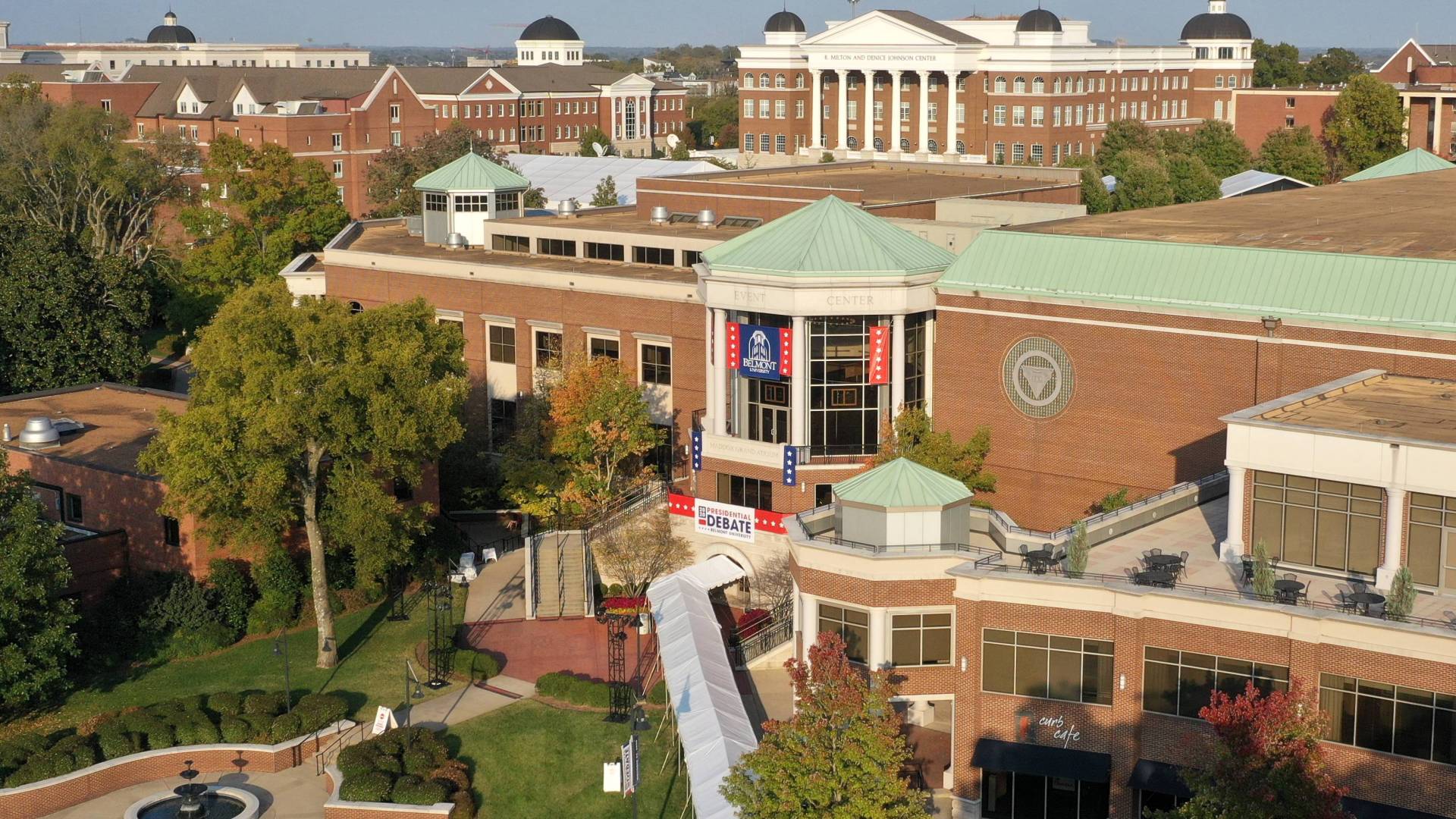 Brick campus buildings with columns, trees, grass, shown from overhead