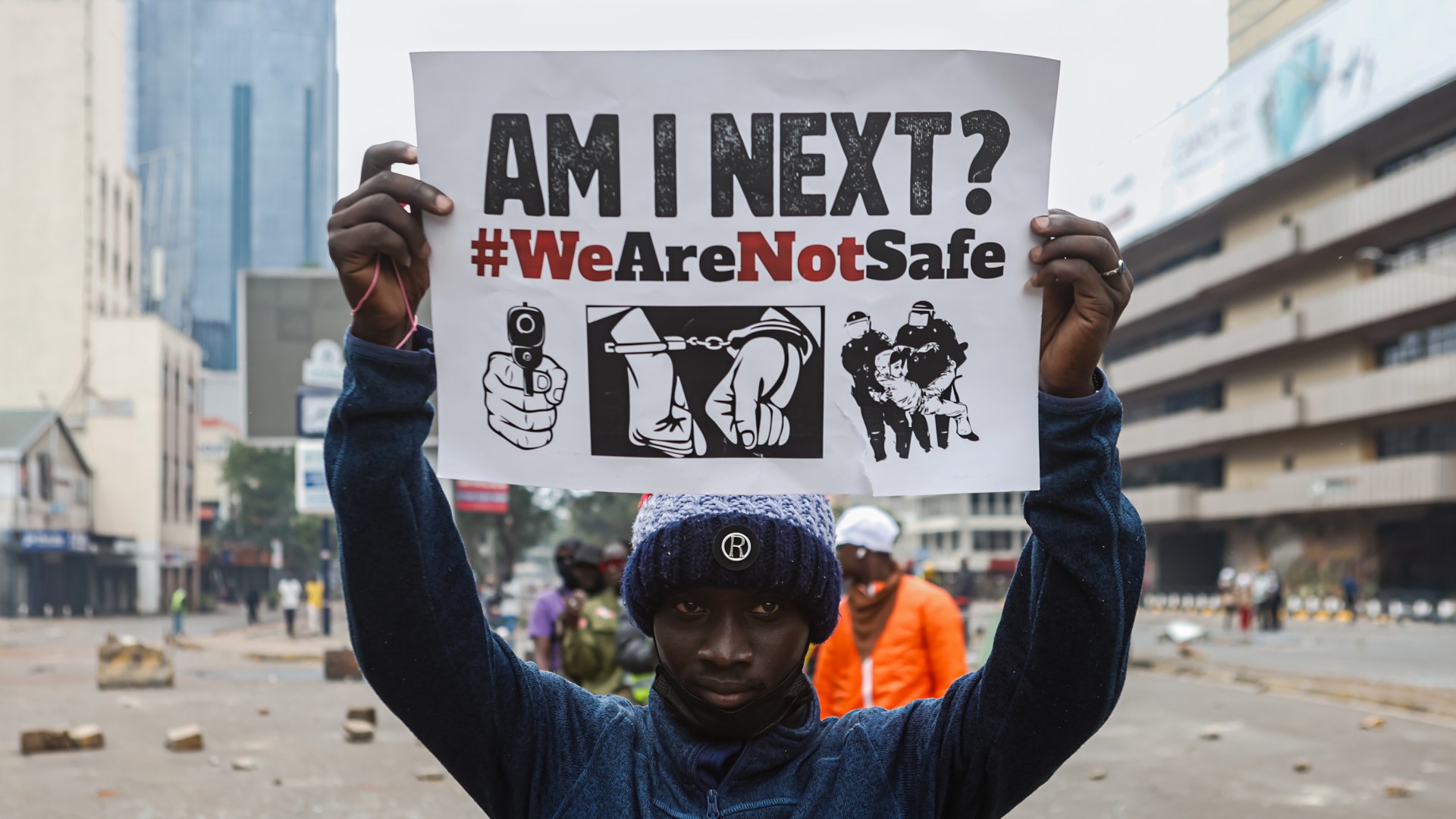 A protester holds a placard during a remembrance march in Nairobi to commemorate one year since many lost their lives in anti-tax demonstrations.