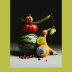 A still life arrangement of fruit, in various states of ripeness against a black background.
