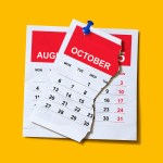 An October calendar ripped in half to show an August calendar.