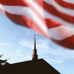 An American flag waving over a church