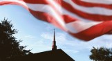 An American flag waving over a church