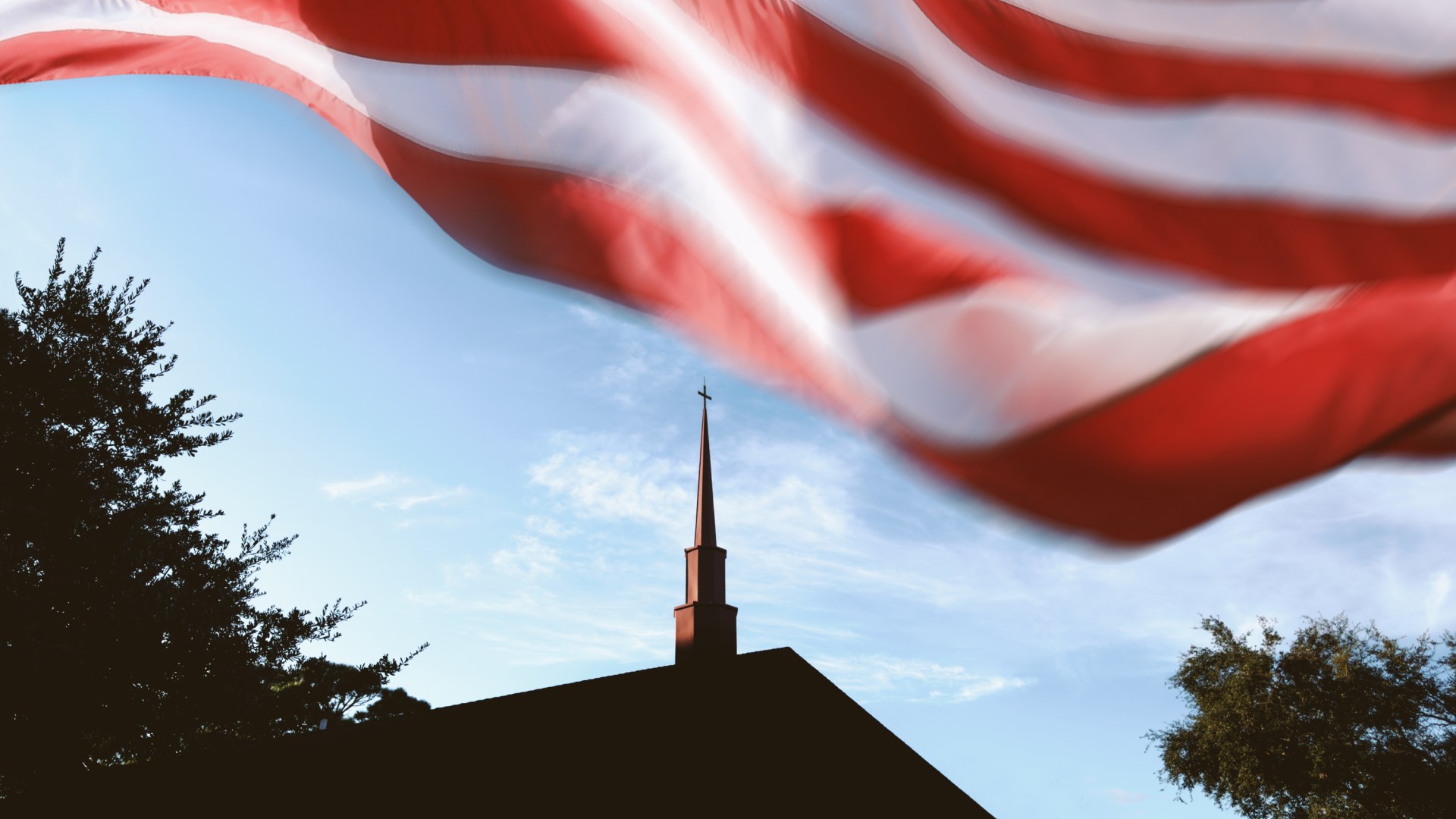 An American flag waving over a church