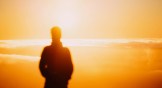 A man standing in front of a golden sunset
