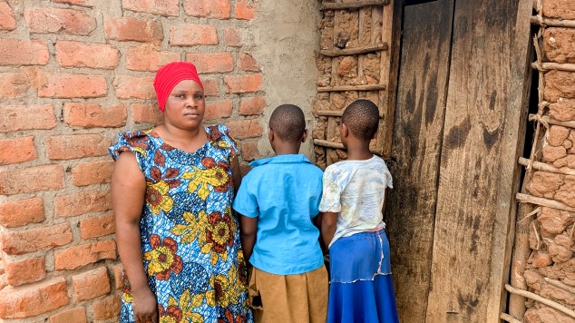 Namuyiga Asfah stands next to her two daughters N. A., age 8, and N. A., age 9.