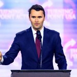 Charlie Kirk speaking on stage at America Fest 2024.