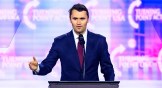Charlie Kirk speaking on stage at America Fest 2024.