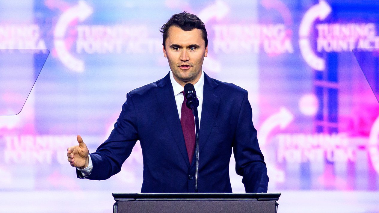 Charlie Kirk speaking on stage at America Fest 2024.