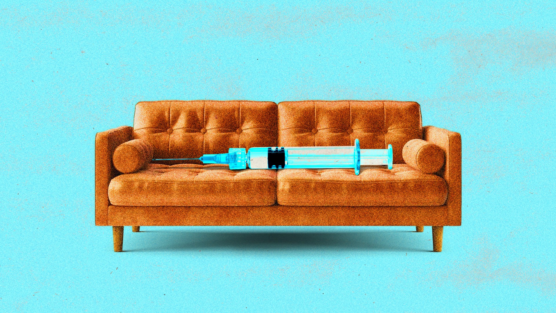 A syringe laying on a couch.